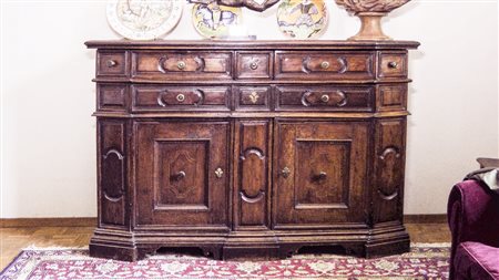 CREDENZA IN NOCE Brescia, XVII secolo di forma scantonata, fronte con doppi...