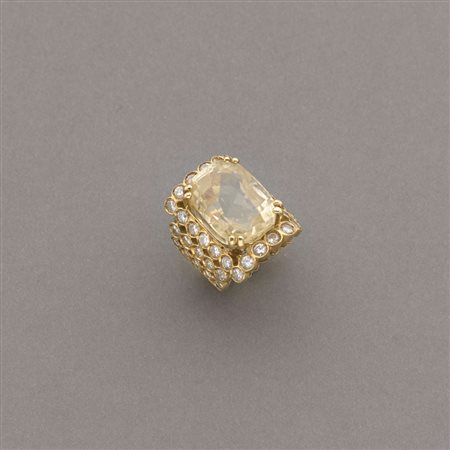 Anello in oro giallo a fascia con pavé di diamanti rotondi ed al centro un...