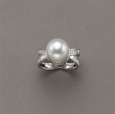 Anello in oro bianco a gambo incrociato con diamanti a baguette e due giri...