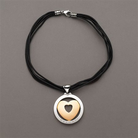 Ciondolo in acciaio e oro con cerchio ed al centro un cuore traforato tenuto...