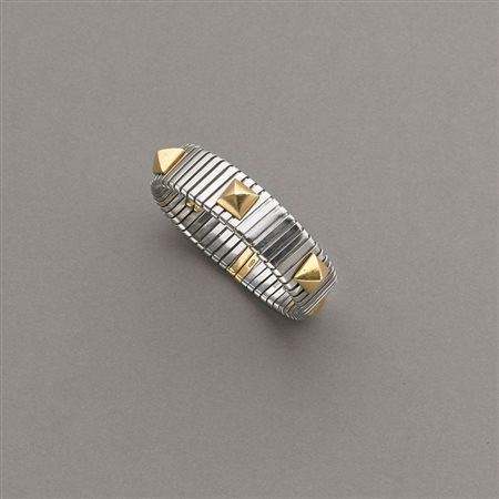 Bracciale aperto semi-rigido e a molla in acciaio con finiture e borchie...