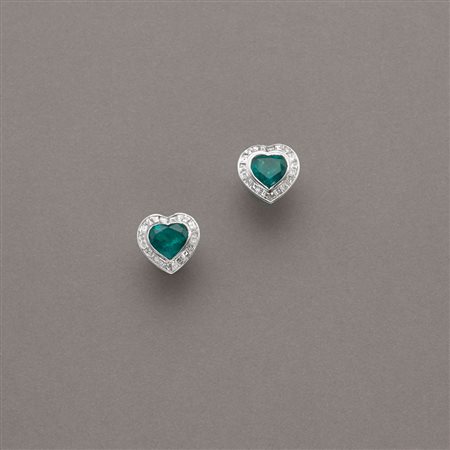 Orecchini in oro bianco a guisa di cuore con al centro due smeraldi di forma...