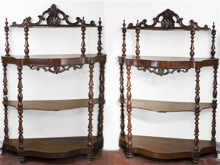 Coppia di étagères in noce a quattro ripiani di forma mossa decorate da fregi...