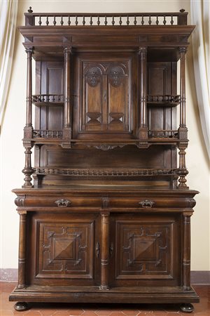 Mobile a due corpi in noce con parte superiore ad un'anta e ripiani a giorno...