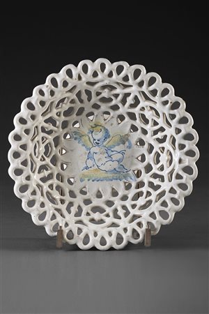 Alzata in maiolica traforata e smaltata bianca decorata nel cavetto con...