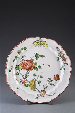 Gruppo di cinque piatti in maiolica a bordo mistilineo decorati in policromia...