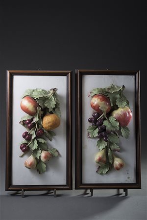 Coppia di placche in porcellana policroma in rilievo con trionfi di frutta In...