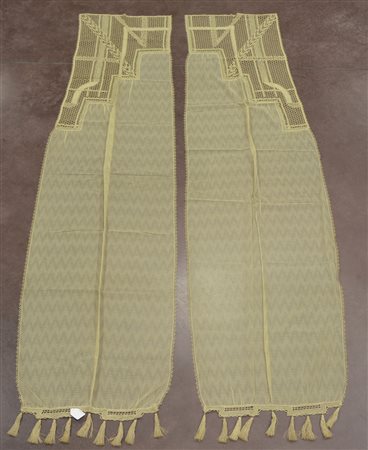 Due tende rete con inserto tombolo decò e fiocchi finali. Sec. XX (cm 227x52)...