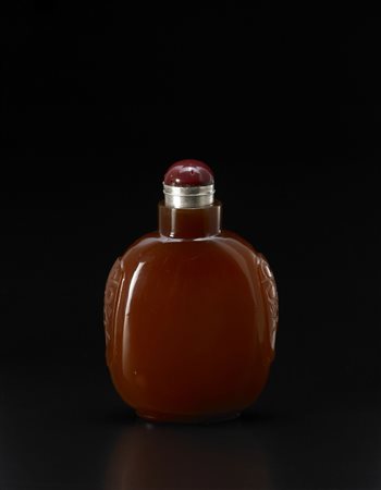 Snuff bottle in corniola di forma arrotondata con mascheroni incisi sui lati,...