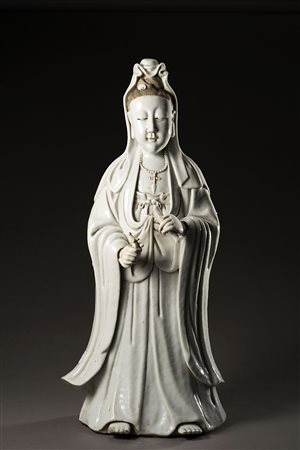 Antica Guanyin in blanc-de-Chine, il capo coperto, indossa lunghe vesti e...