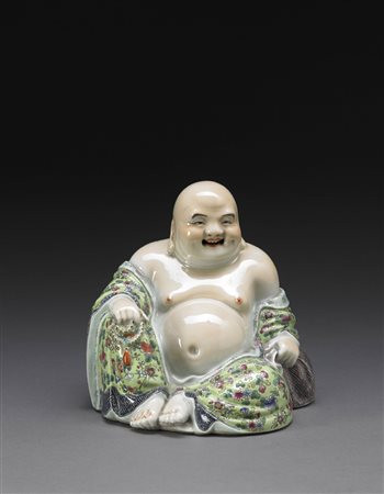 Budai in porcellana a smalti policromi, raffigurato seduto con espressione...