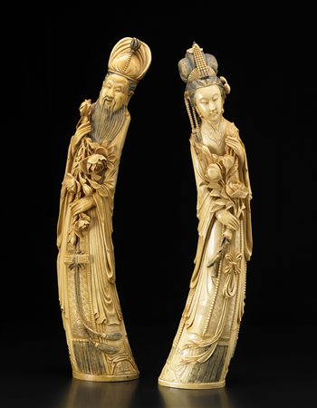 Coppia di dignitari in avorio intagliato, con eleganti vesti decorate ed...