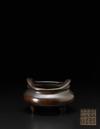 Incensiere tripode in bronzo, il corpo globulare con doppie anse e marchio...