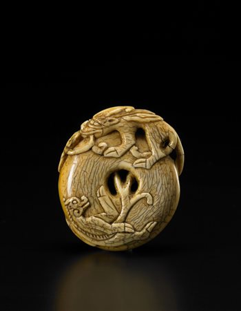 Piccolo intaglio circolare in avorio adornato con due creature mitologiche...