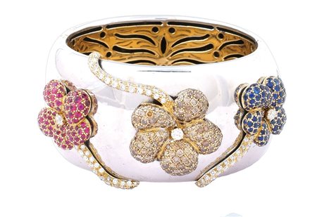 BRACCIALE MANETTA IN ORO BIANCO E GIALLO 18KT con tre fiori applicati in oro...
