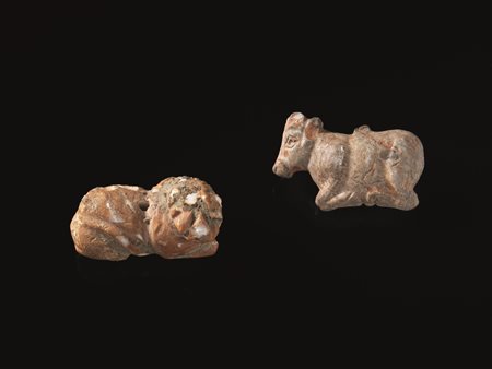 DUE PENDENTI Materia e tecnica: calcare Un bovide accucciato realisticamente...