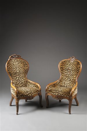Due poltrone in noce con schienali a cimasa intagliata e traforata, gambe...