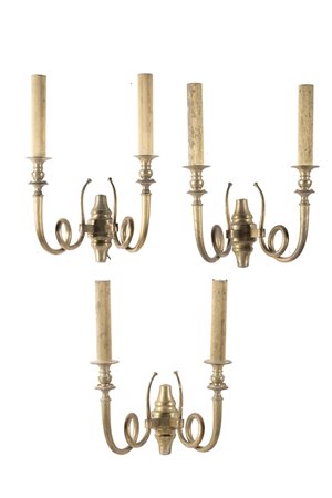 Gruppo di tre appliques a due fiamme in ottone con braccia sagomate e...
