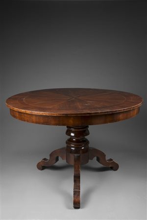 Tavolo di forma circolare con piano intarsiato e filettato in legni vari a...