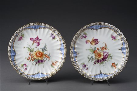 Manifattura tedesca, lotto composto da due piatti decorati al centro con fiori.