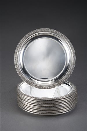 Gruppo di dodici sottobicchieri in argento con bordi decorati a palmette....