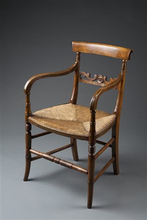 Poltrona in noce con cartella a giorno traforata e intagliata a volute,...