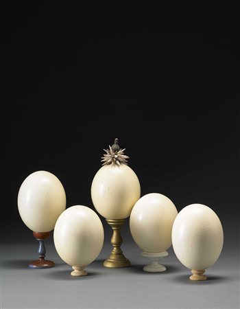 Lotto di cinque composizioni con uova di struzzo poggianti su basi diverse...