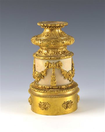 Base a colonna in marmo bianco e bronzo dorato e cesellato a volute fogliate...