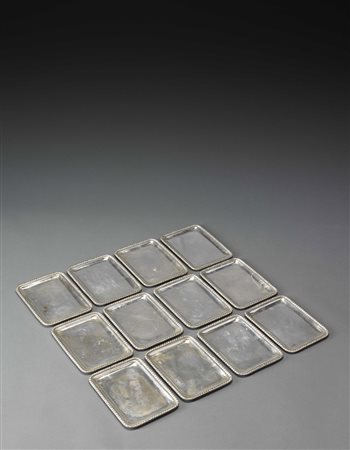 Gruppo di dodici piattini portapane in argento a bordo cordonato (g. 2200)...