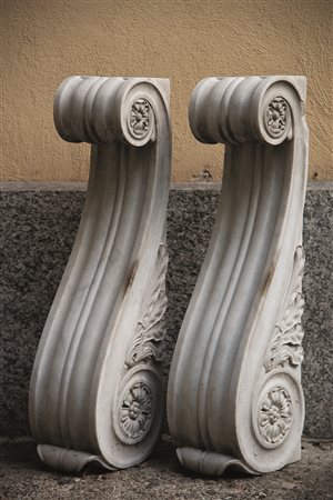 Coppia di montanti in marmo di forma sagomata scolpiti a motivi vegetali e...