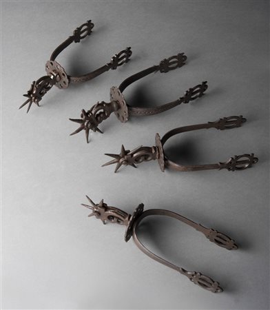 Coppia di speroni in ferro battuto uniti a due diversi decorati a motivi...