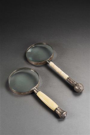 Lotto di due lenti di ingrandimento con manici in avorio e pomoli in argento...