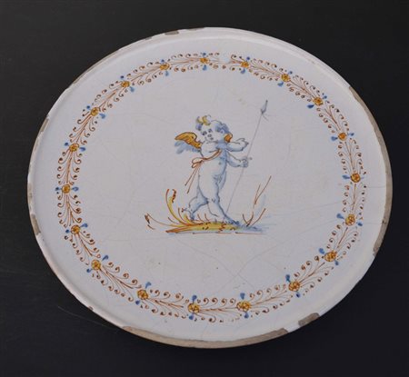 Alzata in maiolica a decorazione compendiaria con putto al centro. Area...