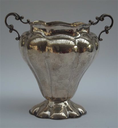 Vaso portafiori in argento con corpo sagomato e anse cesellate a volute....