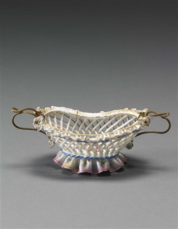 Piccolo cestino ovale in porcellana traforata con bordo rialzato in oro. Al...