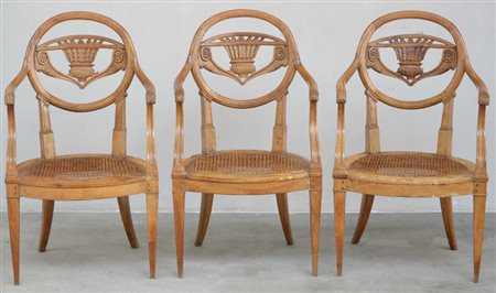 Gruppo di tre poltrone con schienale tondo intagliato e traforato al centro...