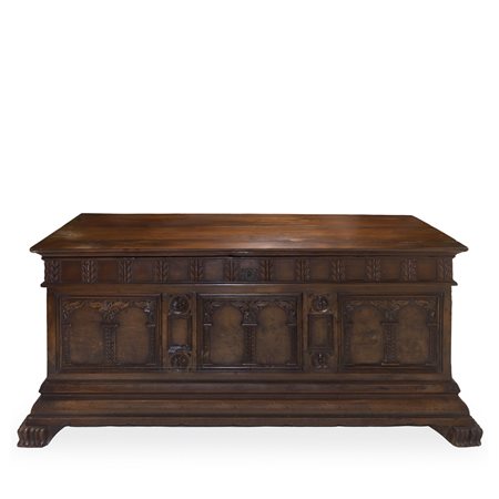 Cassapanca in noce scolpita e intagliata sul fronte con colonne ed archi, piedi felini e cornice bassa aggettante, 18°  secolo