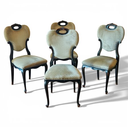 Quattro sedie in noce intagliato ed ebanizzato ricoperte in cotone avorio