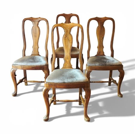Quattro sedie in stile Settecento in noce biondo intagliato, ricoperte in velluto grigio