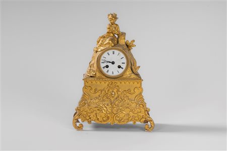 Pendola da appoggio in bronzo dorato sormontata da fanciulla con cagnolino. Francia, secolo XIX