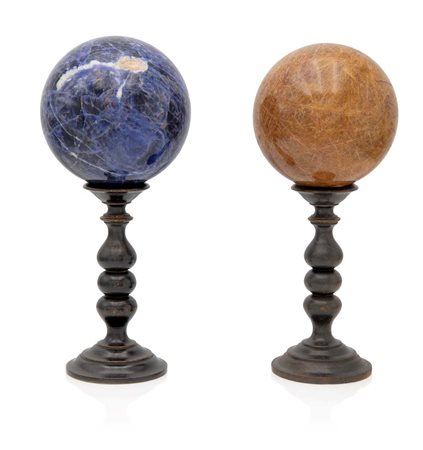 Due sfere diverse con piedistalli in legno tornito una in sodalite ed una in...