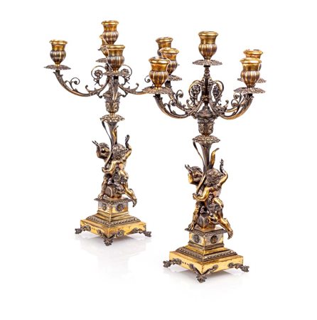 Coppia di candelabri in argento 800/000 dorato, a cinque luci con bracci...