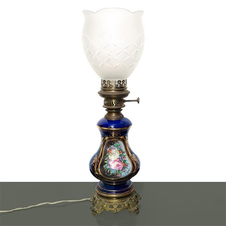 Lume in porcellana blu con fiori policromi dipinti sul fronte entro ovale dorato con diffusore in vetro intagliato