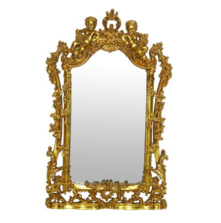 Specchiera sagomata entro cornice dorata riccamente decorata a traforo con due bacchini alla sommità