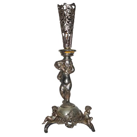 Candeliere in metallo con putto reggicandela, puttini alla base e  decori a traforo