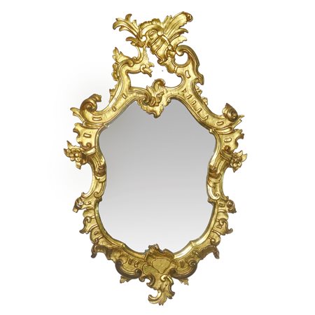 Specchiera sagomata entro cornice dorata con decoro traforato alla sommità