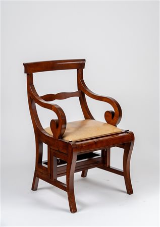 Poltrona con braccioli terminanti a ricciolo convertibile in scaletta da biblioteca in legno intagliato e lastronato. 