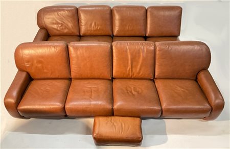 Divano componibile composto da otto moduli e un poggiapiedi in pelle marrone. I