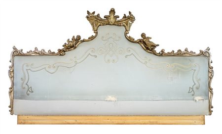 Testiera da letto in legno intagliato e dorato a mecca, cimasa decorata a volut