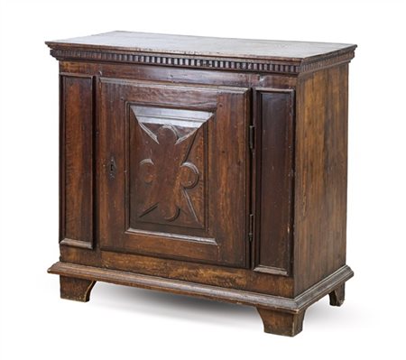 Stipo in legni vari con fronte a un'anta bugnata a motivo geometrico, piano con